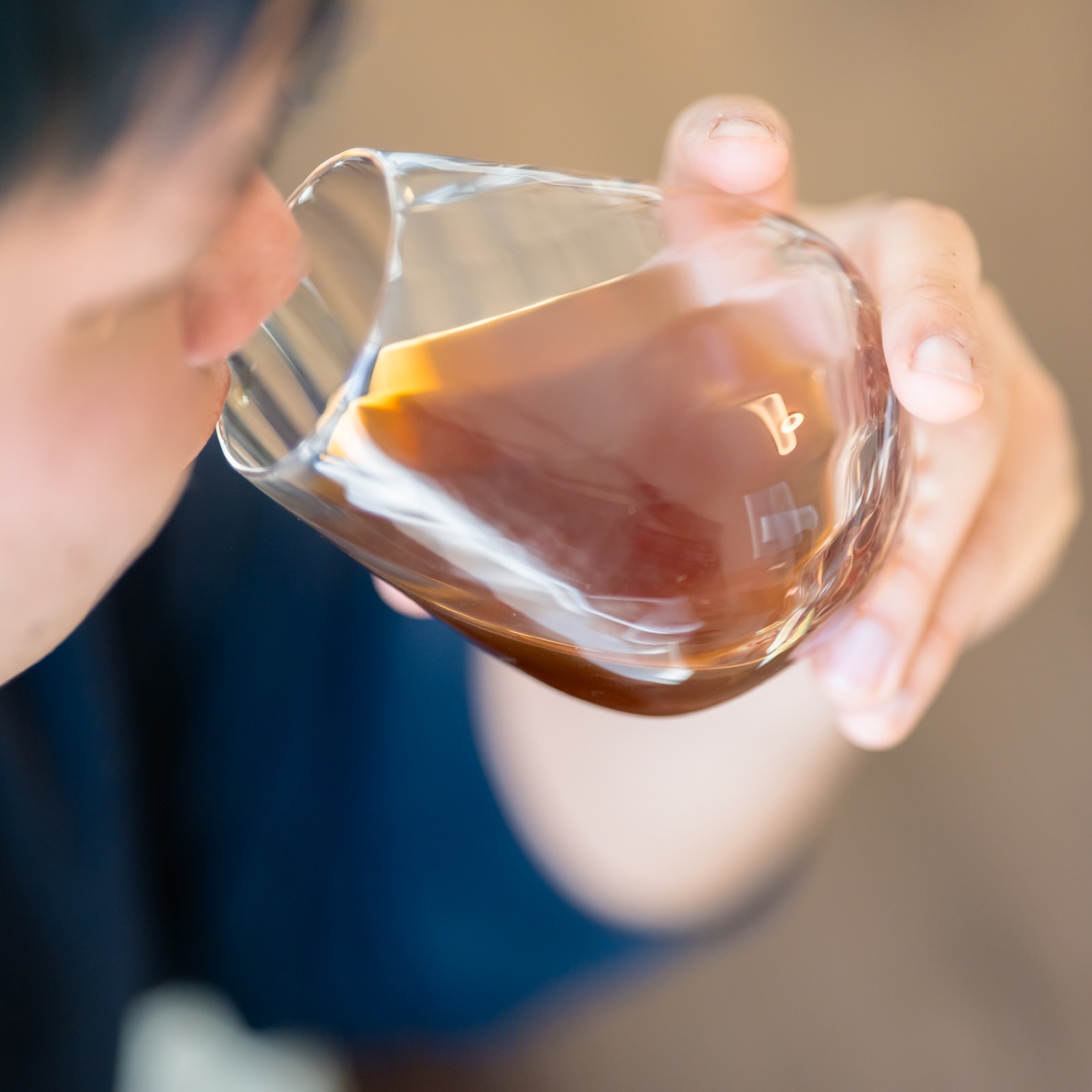 コーヒーを飲みながら苦味と香ばしさの質を確かめる様子