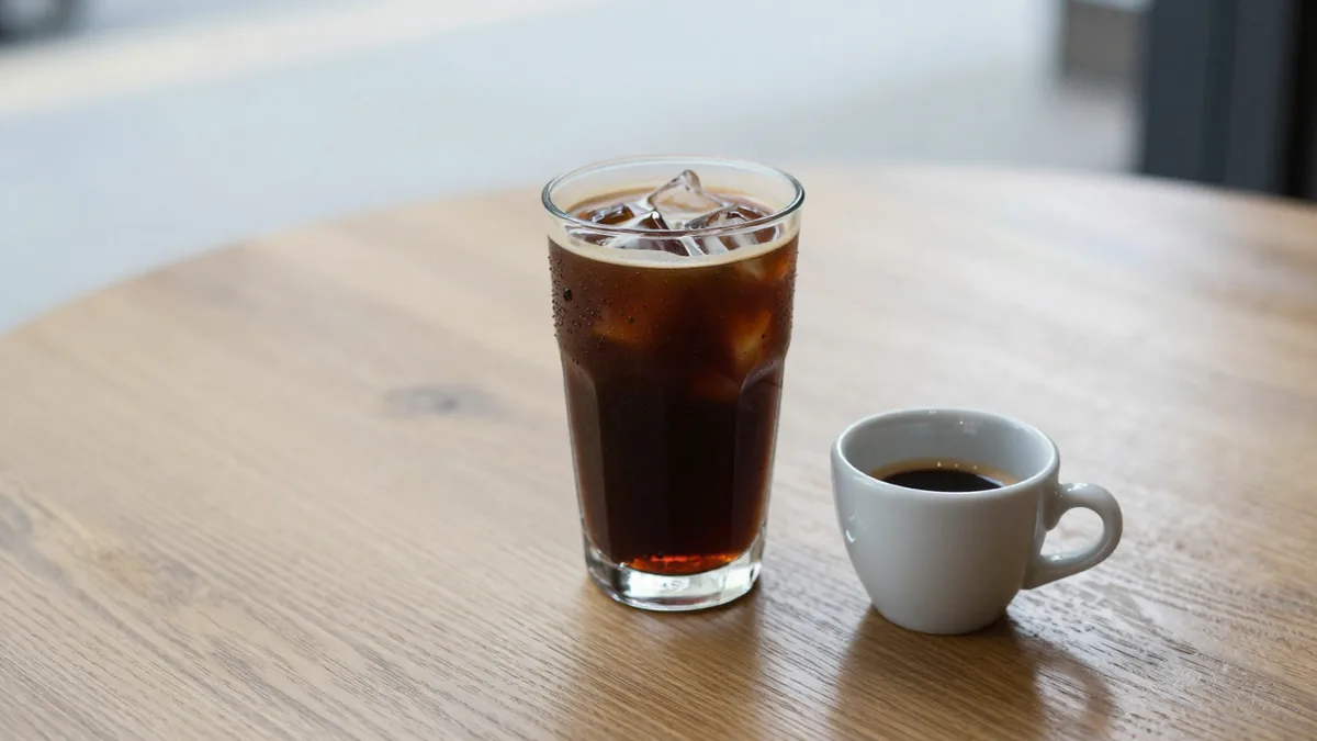 氷を入れたグラスのアイスコーヒーと、小さなカップのエスプレッソ