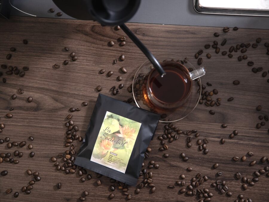 農園、品種、精製方法が記載されたEL ORIGENのペルー産ゲイシャのコーヒー豆と一杯のコーヒー